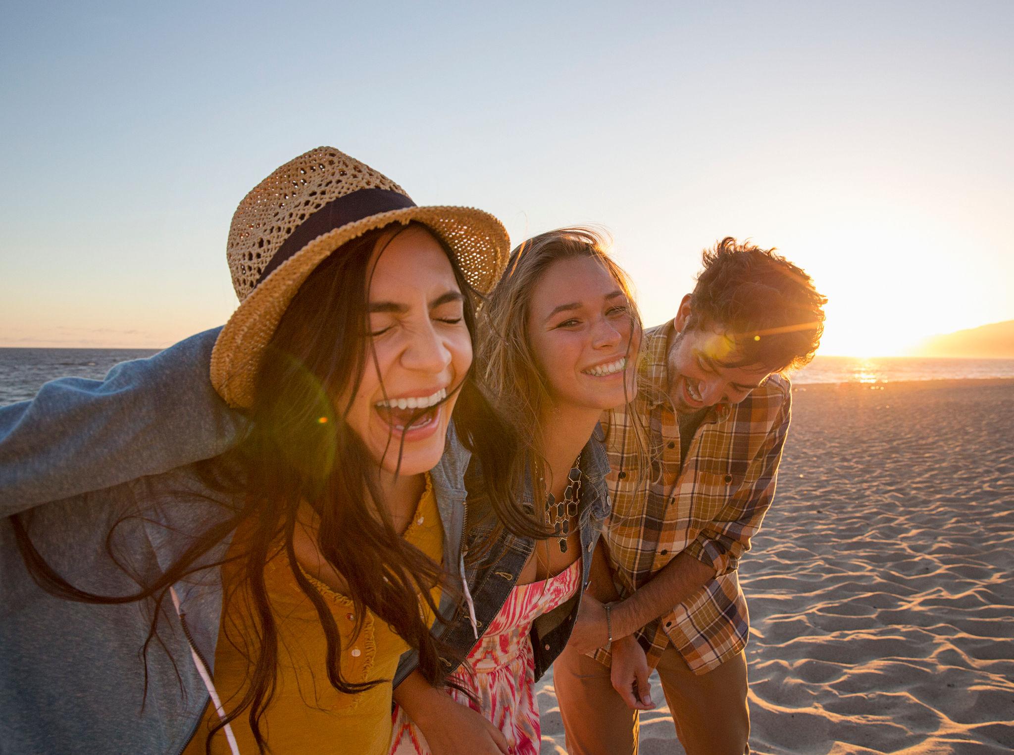 Friends laughing while on the beach
