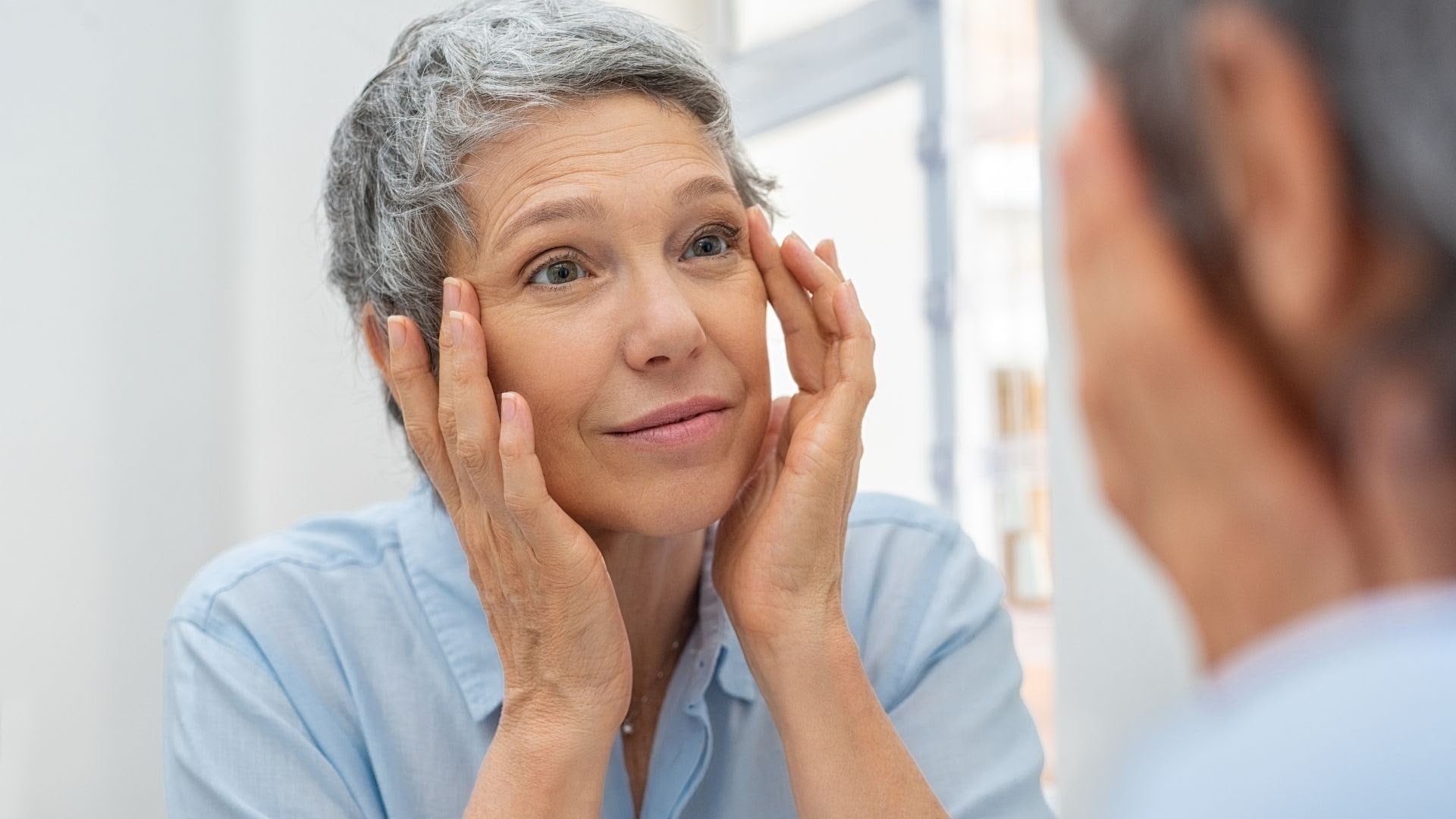 A middle aged woman checking reflection in the mirror